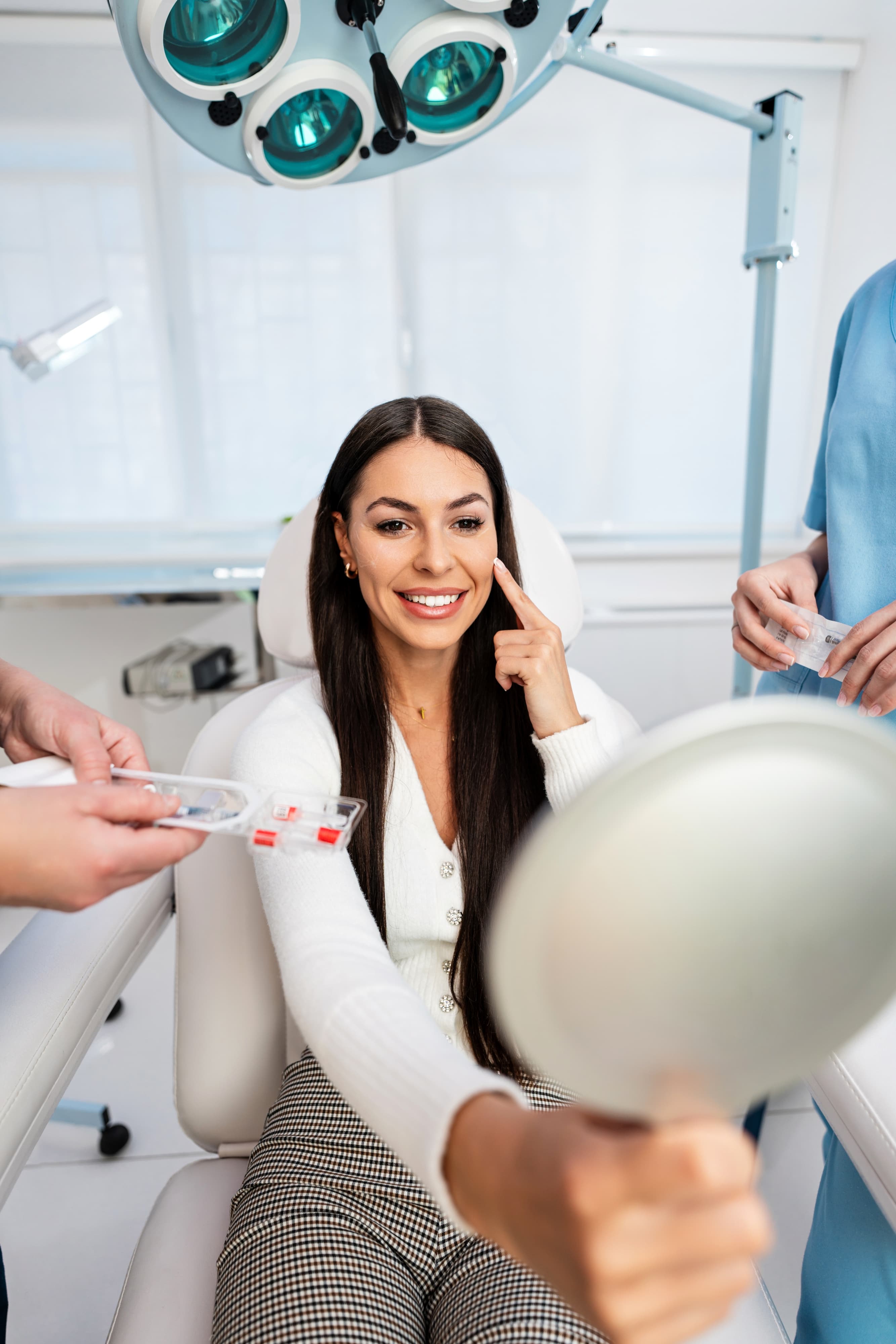 Gloved hands demonstrating an injectable treatment on a smiling patient during a consultation